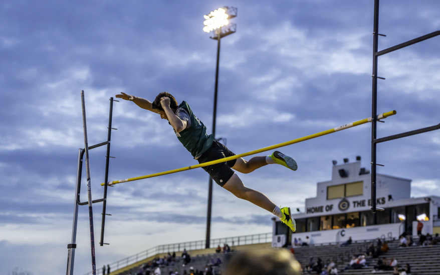 boy jumping over pole